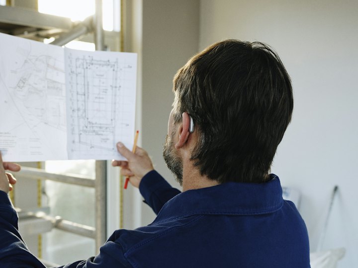Contractor reviewing building plans on site